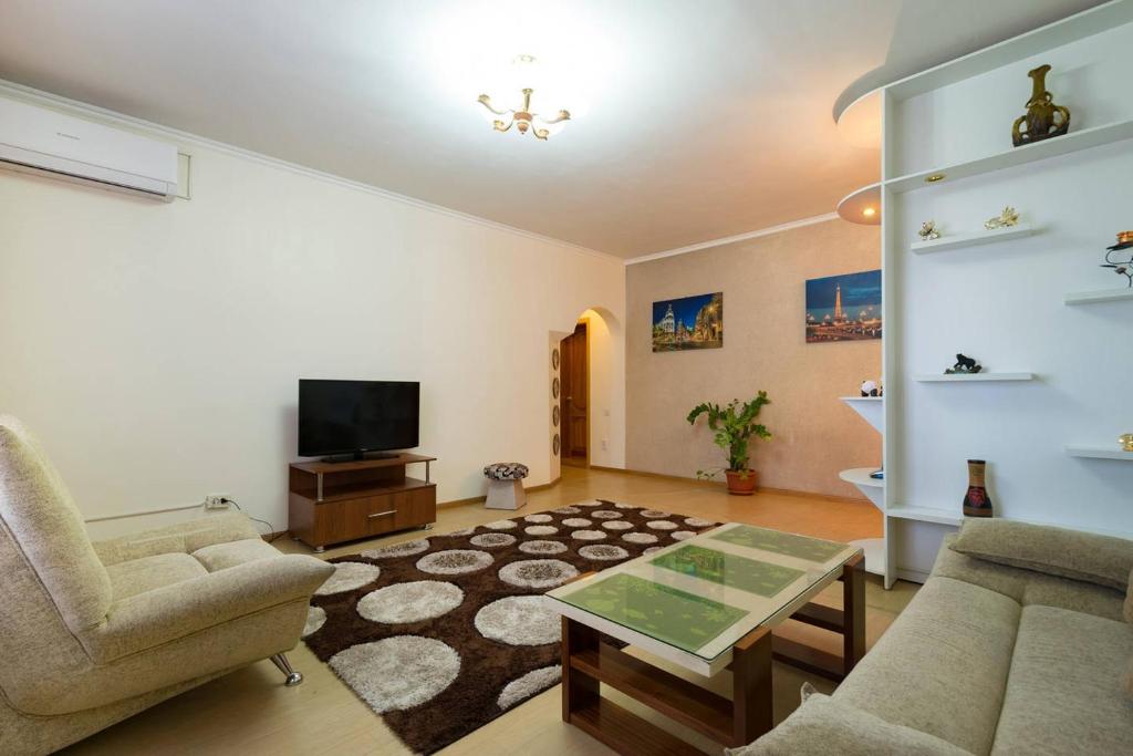 uma sala de estar com um sofá e uma mesa em Nadezhda Apartments in Samal em Almaty