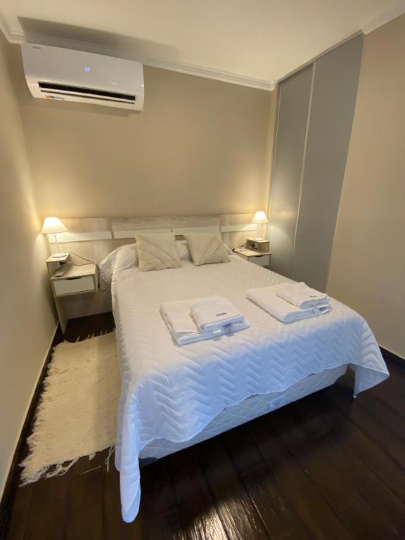 1 dormitorio con 1 cama blanca y 2 toallas en Hermoso Dpto 5 - Camba Cuá - Corrientes en Corrientes