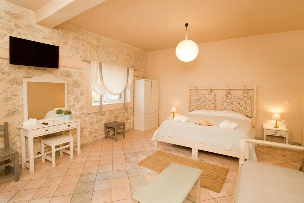 a bedroom with a bed and a table and a desk at Paloma Luxury Studios in Panormos Kalymnos