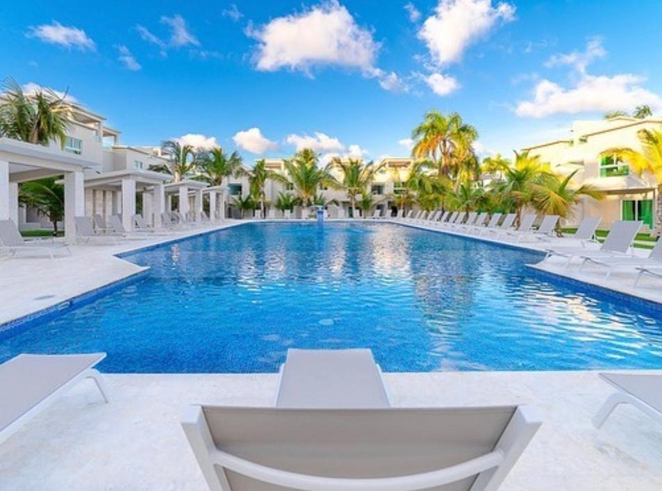 a swimming pool in a villa with palm trees at Playa Palmera Beach Resort in Punta Cana