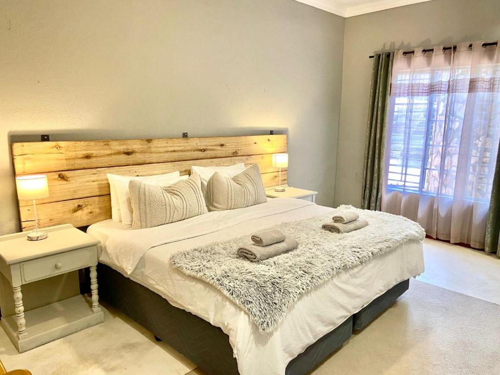 een slaapkamer met een groot bed met twee handdoeken erop bij Selah Guest Cottages Self-catering Farmstay Accommodation in Nelspruit