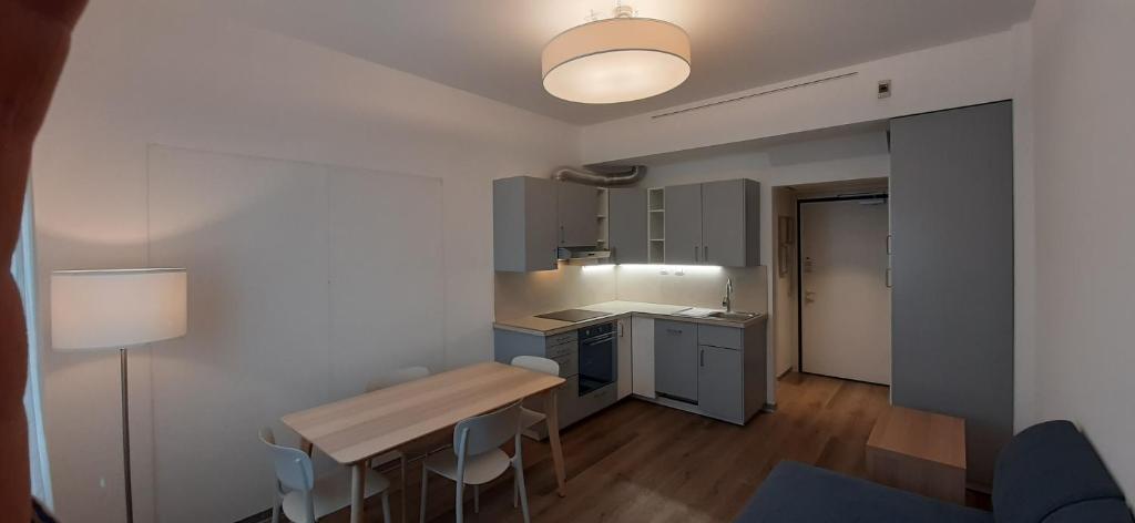 kuchnia ze stołem i krzesłami w pokoju w obiekcie Delta Hotel Apartments w mieście San Donato Milanese