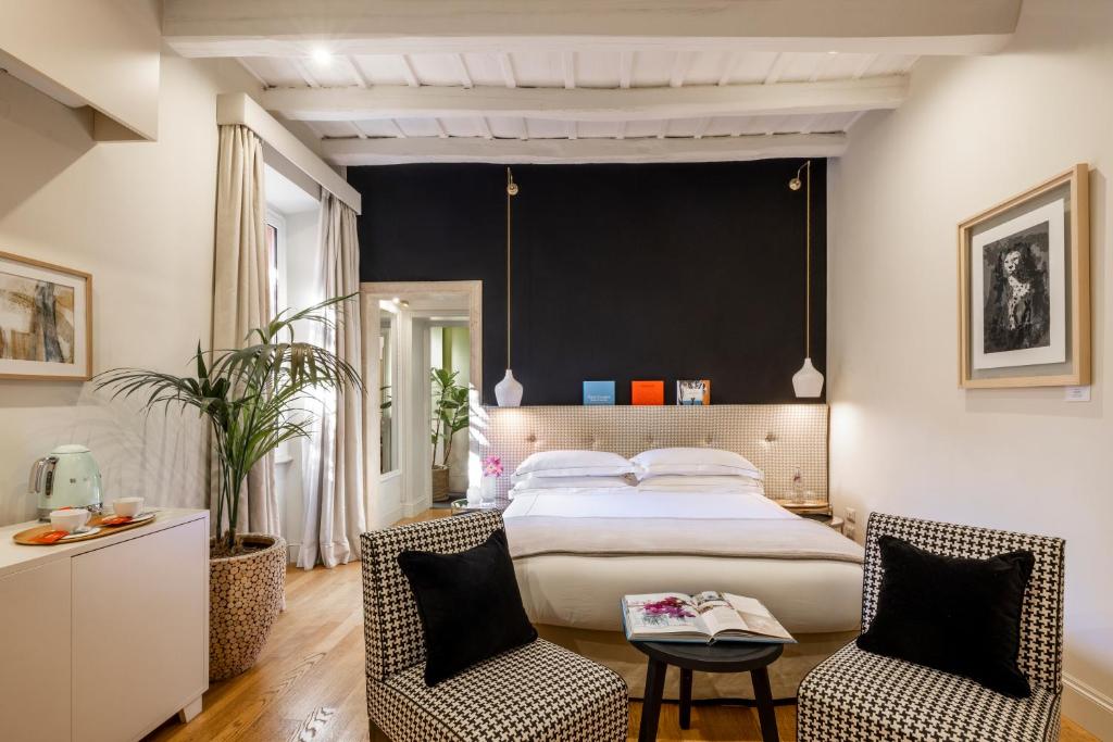 a bedroom with a large bed and two chairs at Nerva Boutique Hotel in Rome