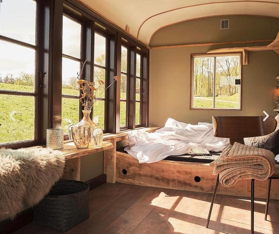 una camera con letto, tavolo e finestre di Sol-flora a Tjele
