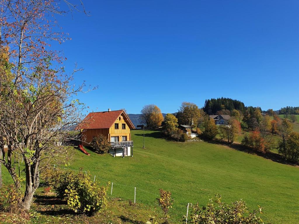 una casa en una colina con un campo verde en Ferienhaus Lärchenhütte, en Kasperle