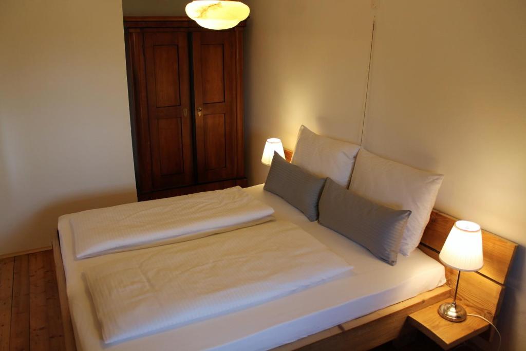 1 cama con sábanas blancas y almohadas en una habitación en Holzer-Hof, 