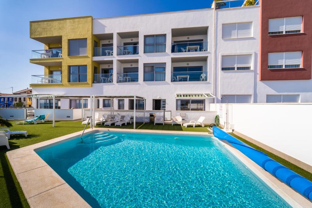 an apartment with a swimming pool in front of a building at Aptos La Punta by DLV in Villajoyosa