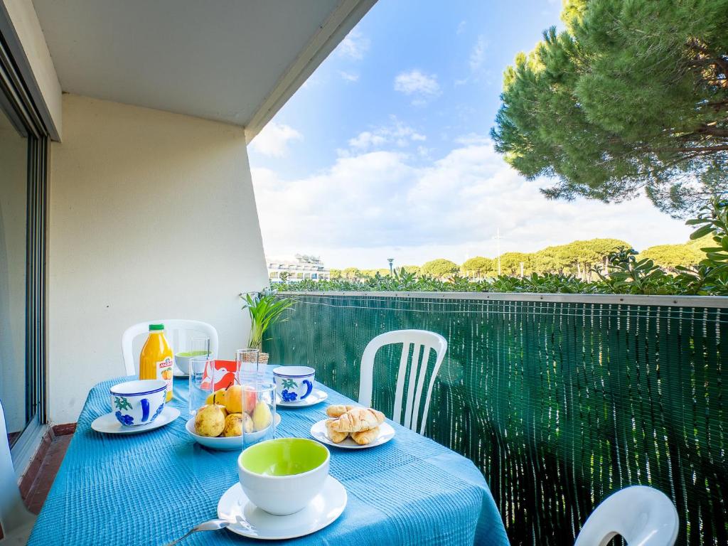 einen Tisch mit Tellern aus Essen auf einem Balkon in der Unterkunft Apartment Le Grand Pavois-3 by Interhome in Le Grau-du-Roi