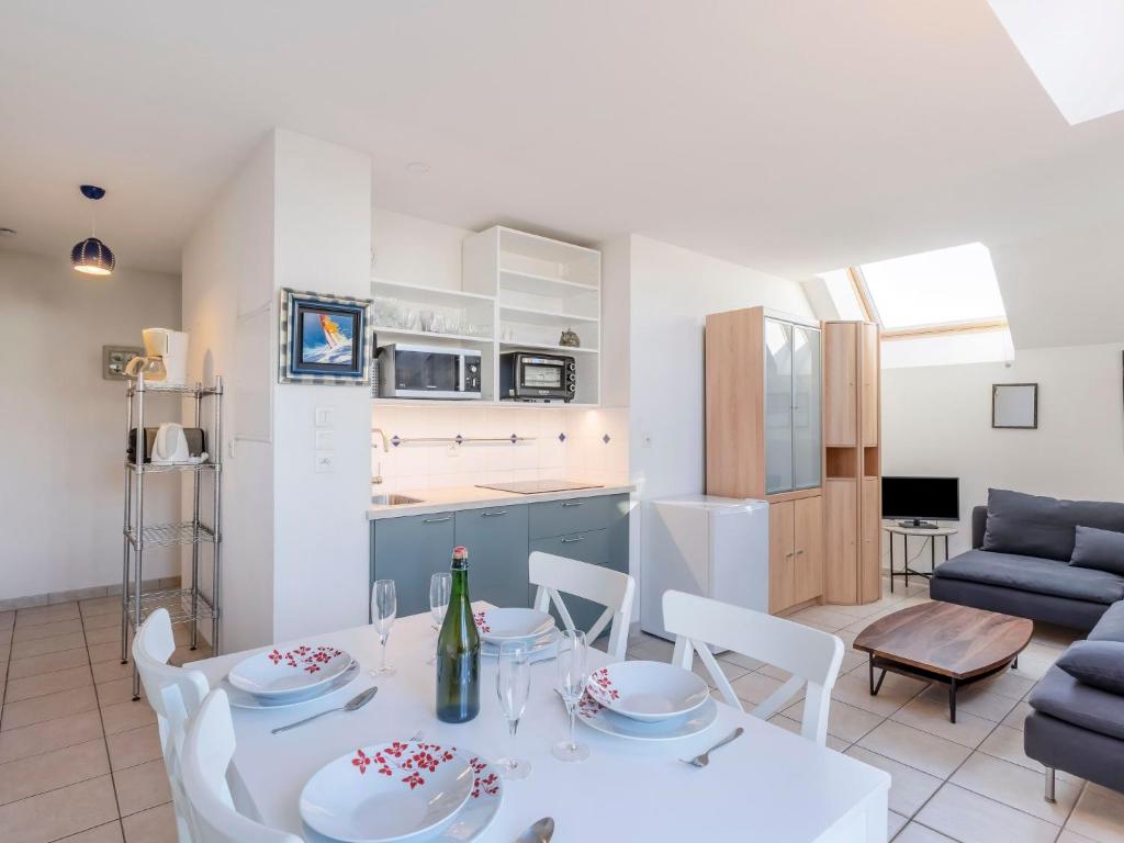 une cuisine et un salon avec une table et des chaises blanches dans l'établissement Apartment Les Marines 1 et 2-7 by Interhome, à Cabourg