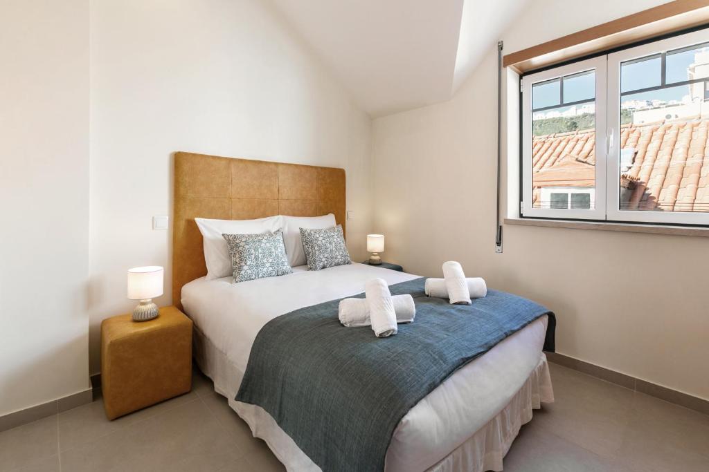 um quarto com uma cama grande e uma janela em Nazaré Boutique Apartment II na Nazaré