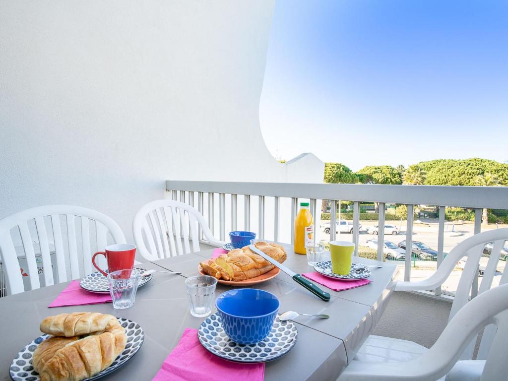 einen Tisch mit einem Frühstück mit Croissants und Brot in der Unterkunft Studio Le Cormoran-5 by Interhome in Le Grau-du-Roi