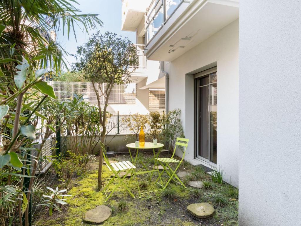 a small garden with a table and chairs in front of a building at Apartment Villa Marine by Interhome in Arcachon
