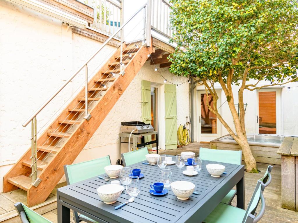 a blue table and chairs on a patio with a staircase at Holiday Home La Belle Tendel by Interhome in Arcachon