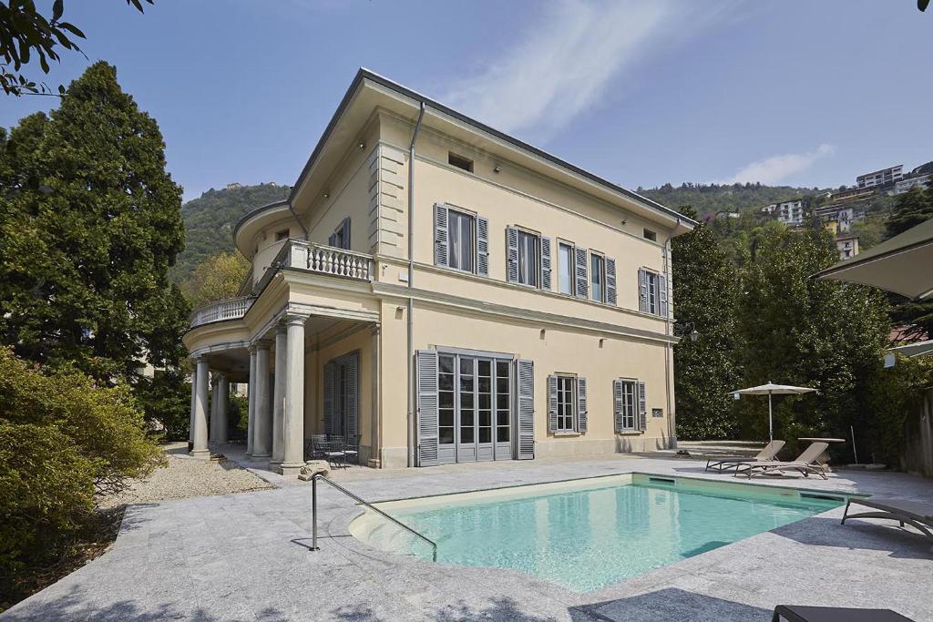 una casa grande con piscina frente a ella en Villa Platamone, en Como