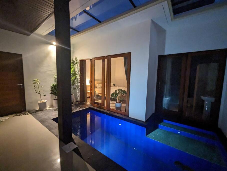 a swimming pool in the middle of a house at Bright Peaceful Villa in Kerobokan