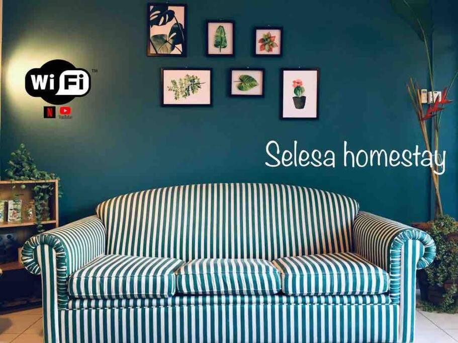 ein Wohnzimmer mit einem Sofa und einer blauen Wand in der Unterkunft THE GREEN @SELESA HILLHOMES BUKIT TINGGI BENTONG in Bentong