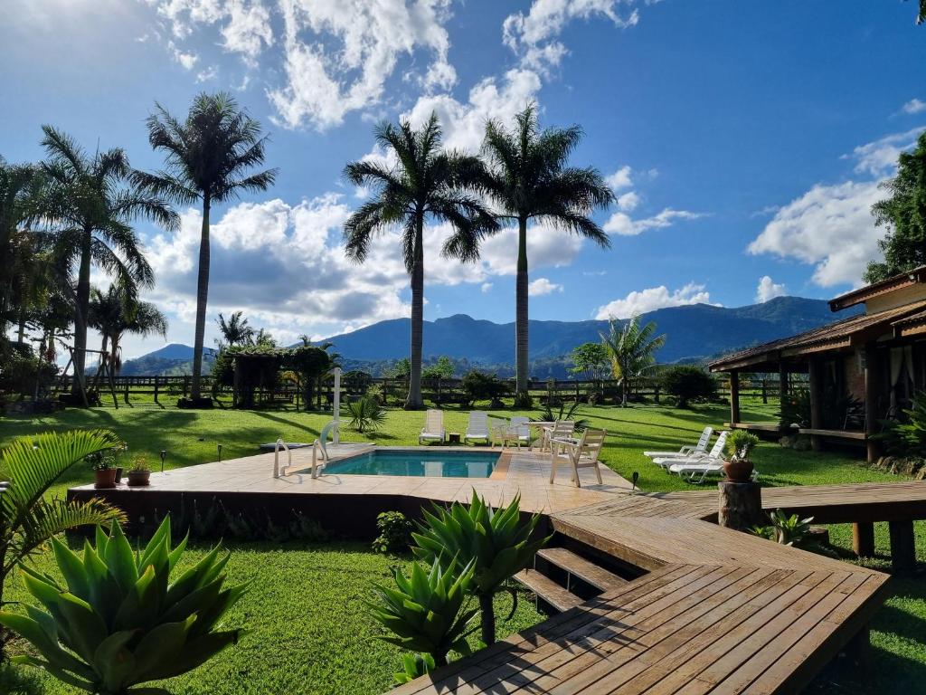 um resort com piscina e palmeiras em Contempla Joanópolis em Joanópolis