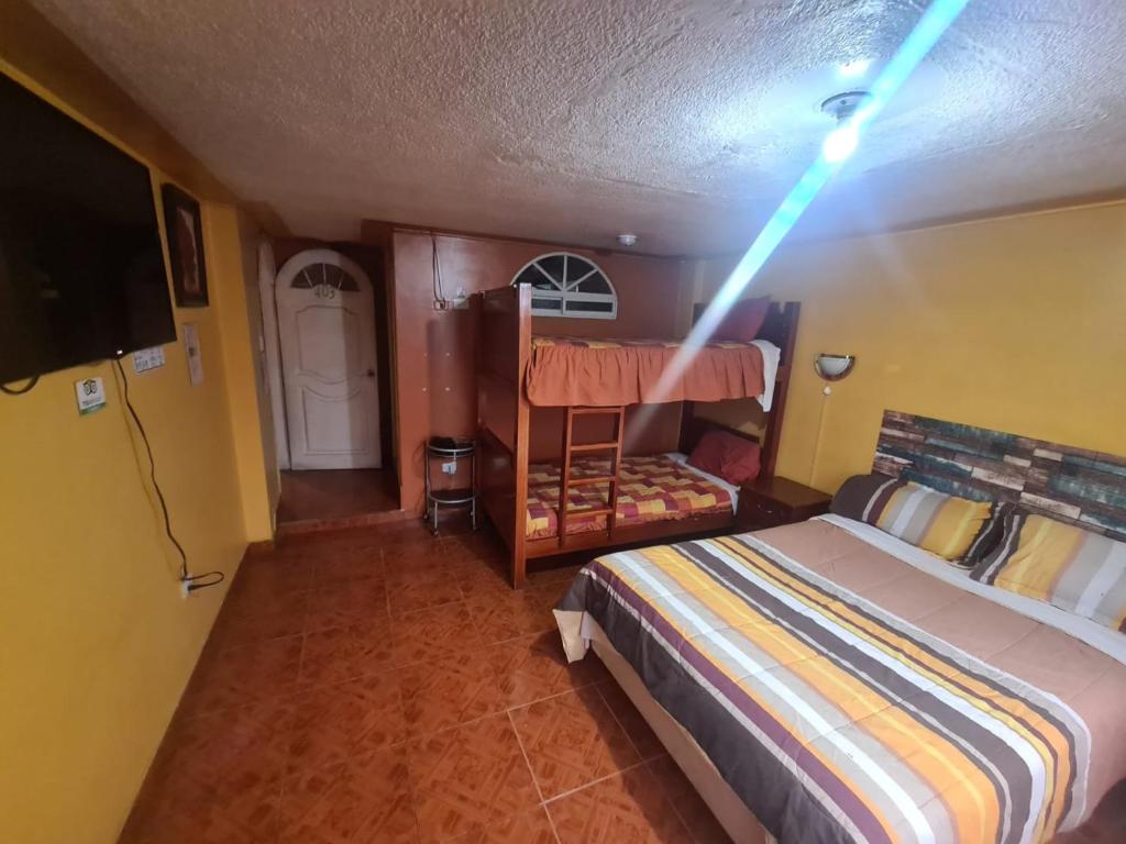 a bedroom with a bunk bed with a light on the ceiling at Hostal Miguel Ángel in Quito