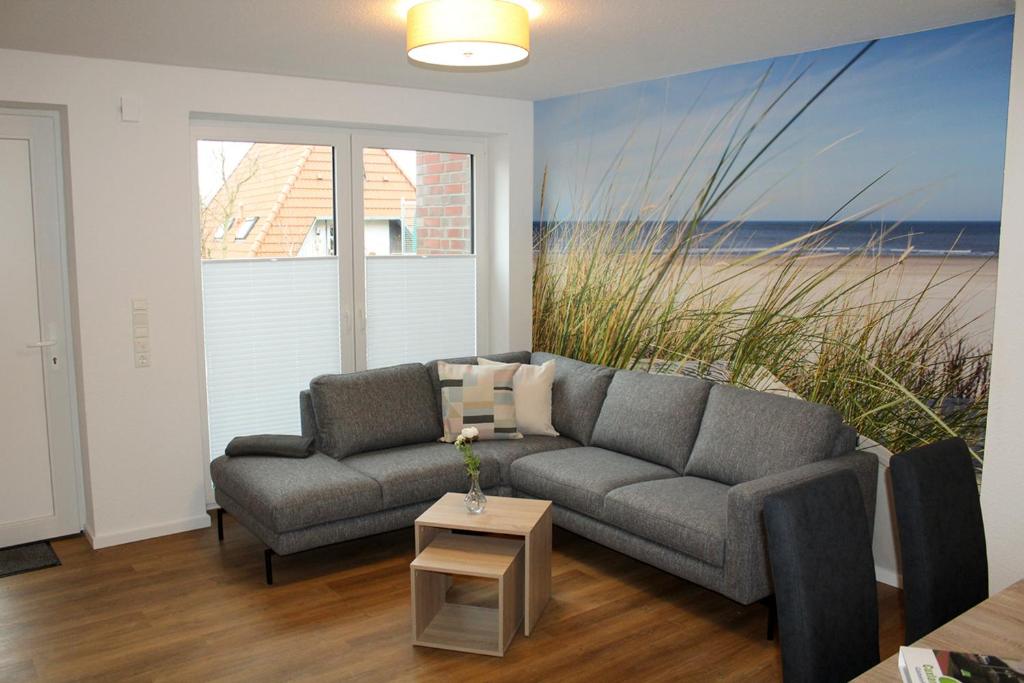 a living room with a couch and a painting of the beach at LA2 f - Ferienreihenhaus LA2 in Schottwarden