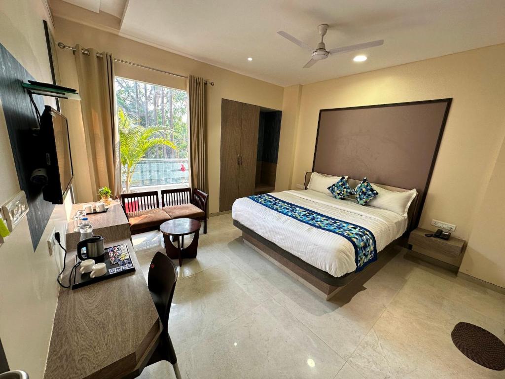 a bedroom with a bed and a large window at Hotel Pinaka Inn in Lucknow