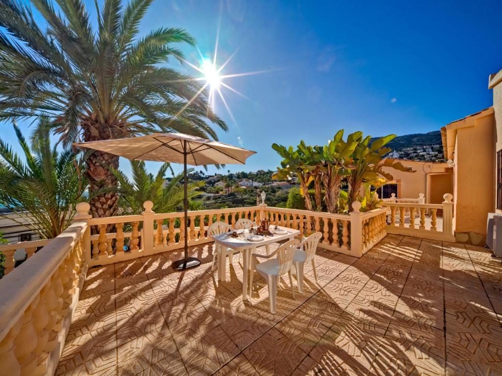 卡爾佩的住宿－Apartment Canuta Baja 3 by Interhome，一个带桌子和遮阳伞的庭院
