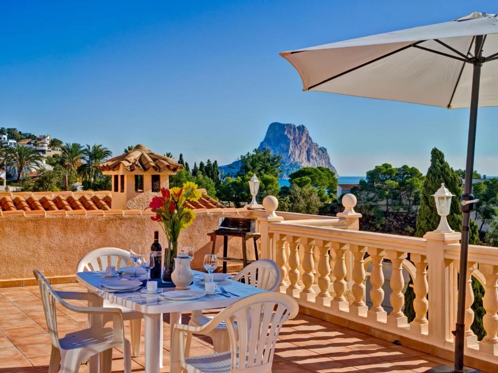 a table and chairs on a balcony with an umbrella at Apartment Canuta Baja 4 by Interhome in Calpe