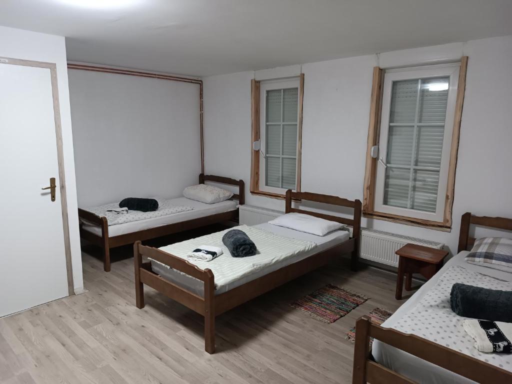 a room with three beds and two windows at studio apartman Ervi in Hlebine