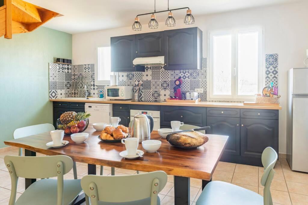 - une cuisine avec une table en bois et de la nourriture dans l'établissement Le N5 des Hauts de Sarlat Apt Duplex Clim, Piscine, Parking, à Sarlat-la-Canéda