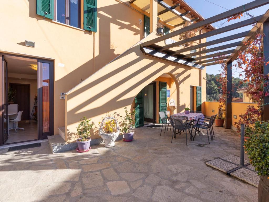 eine Terrasse mit einem Tisch und Stühlen neben einem Gebäude in der Unterkunft Apartment A' Ca' de Alida by Interhome in Ortovero