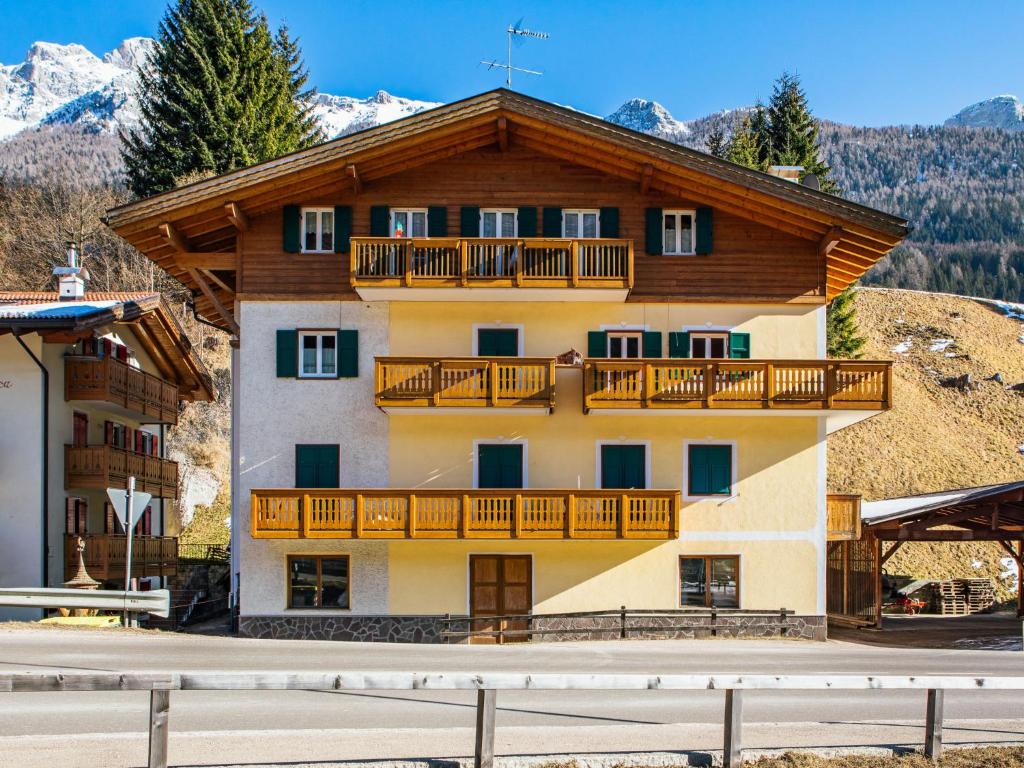 un edificio de apartamentos con balcones y montañas cubiertas de nieve en Apartment Pederiva - SOF743 by Interhome, en Soraga