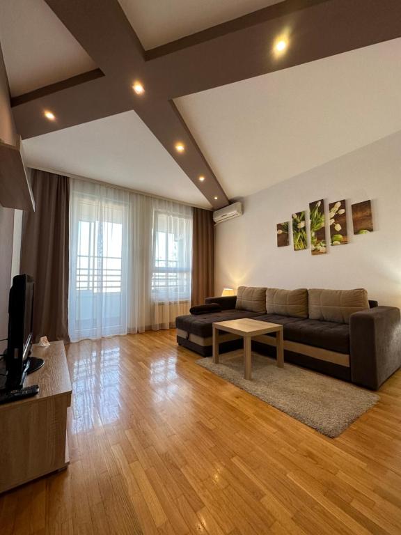 een woonkamer met een bank en een tafel bij Nevena Belville Apartments in Belgrado