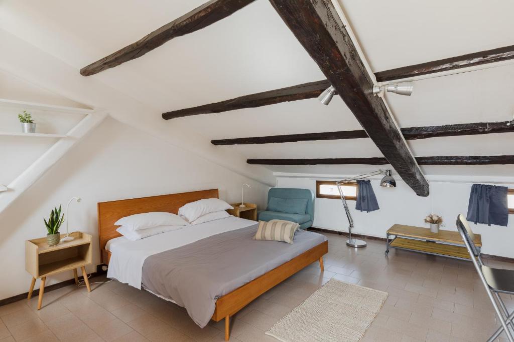 ein Schlafzimmer mit einem Bett und einem blauen Stuhl in der Unterkunft La mansarda del Papa - Zen Real Estate in Rom