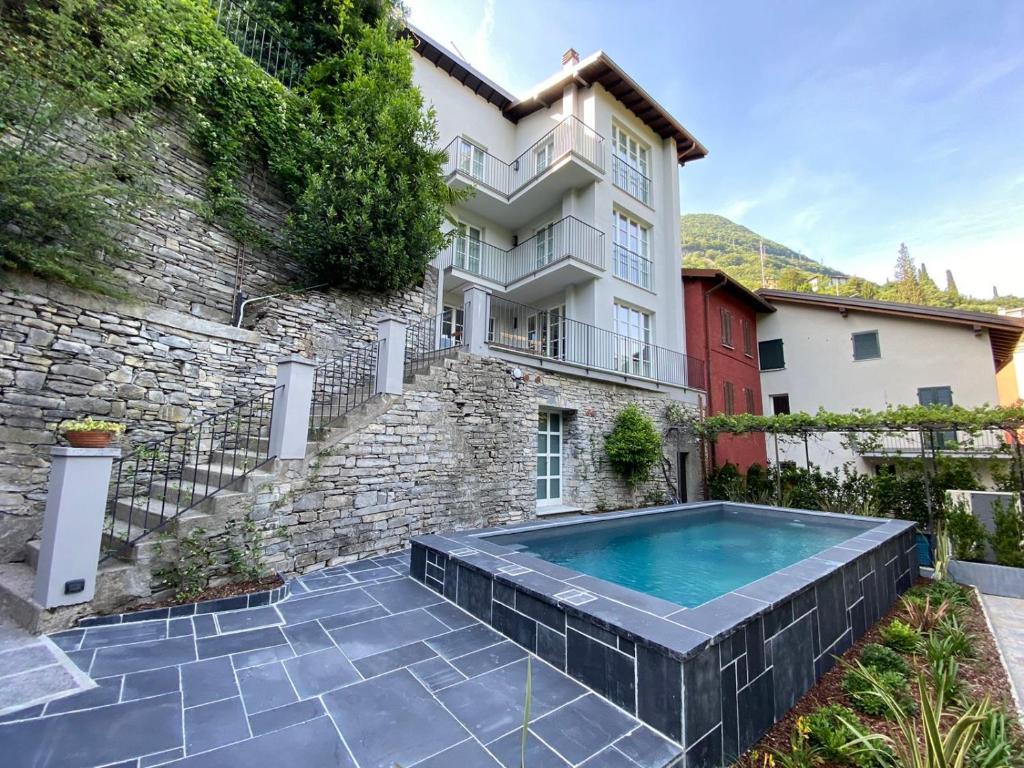 a house with a swimming pool in front of a building at Villa Sole Carate Urio – Lake Como in Carate Urio