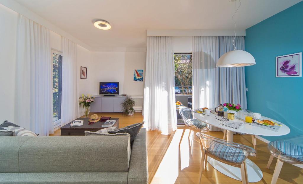 - un salon avec des murs bleus, une table et des chaises dans l'établissement Greystar Apartment Dubrovnik, à Dubrovnik