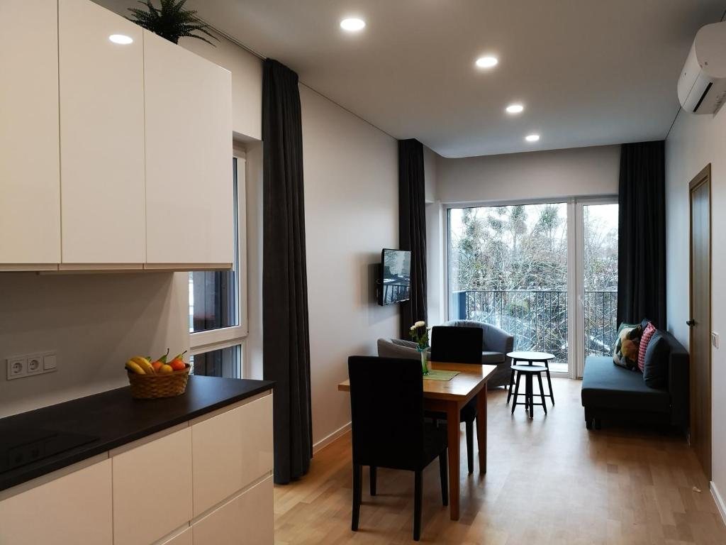 a kitchen and living room with a table and chairs at Apartamentai centre in Birštonas
