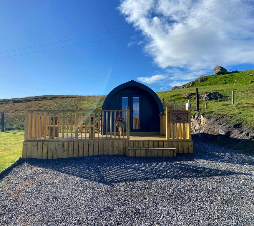 Cabaña pequeña con valla y colina en Meall Ard Self Catering Pod - Isle of South Uist, en Pollachar