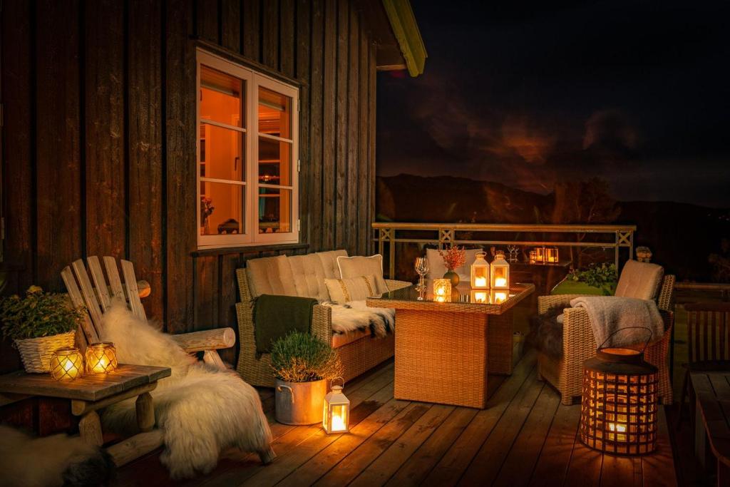 ein Wohnzimmer mit einem Sofa und Stühlen auf einer Veranda mit Beleuchtung in der Unterkunft Skåbu Fjellhotell in Skåbu