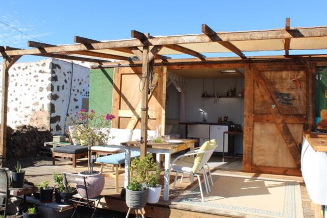 a patio with a table and chairs and a kitchen at Micro House (Back to Nature) in La Oliva