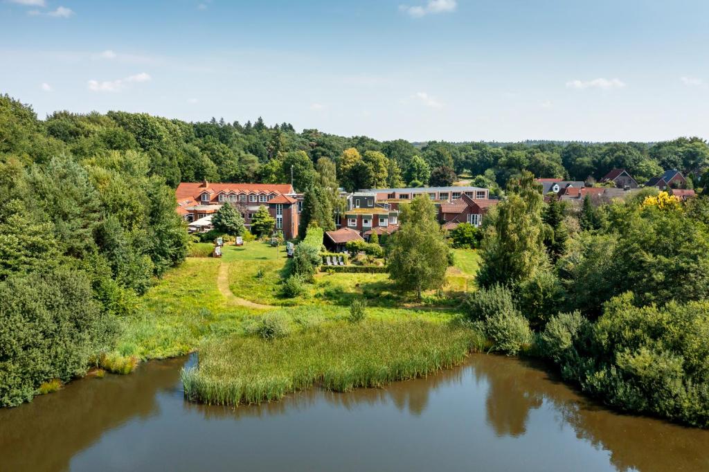 an aerial view of a house next to a river at Köhlers Forsthaus Wellness & Genuss Hotel in Aurich