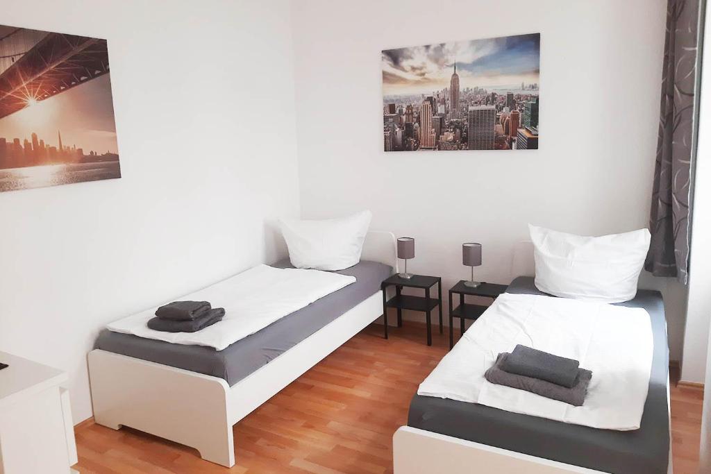 Zimmer mit 2 Betten und einem Bild an der Wand in der Unterkunft Gemütliches Apartment nahe der Elbe in Magdeburg