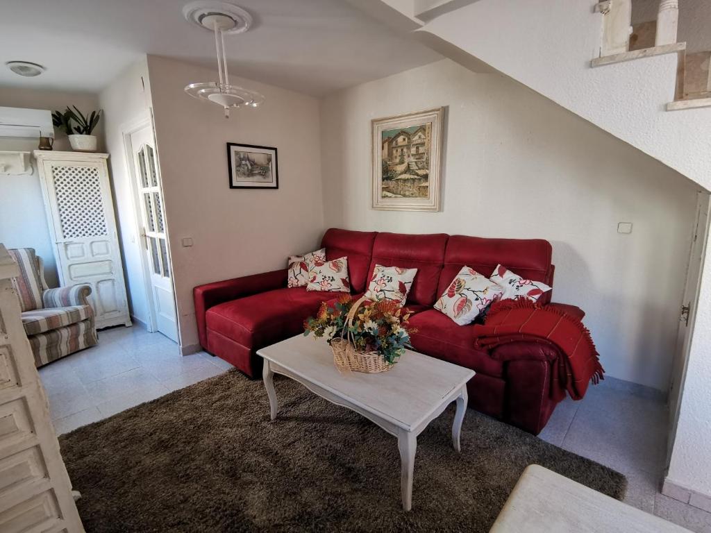 uma sala de estar com um sofá vermelho e uma mesa em Casa Alfonso Toledo Más que una casa un hogar em Toledo
