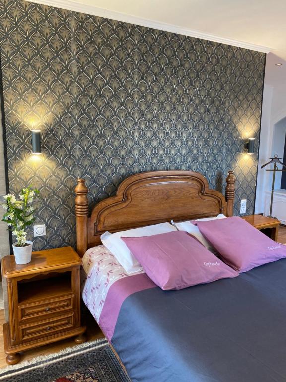 a bedroom with a large bed with purple pillows at Domaine de la Provençale in Saint-Didier-de-la-Tour