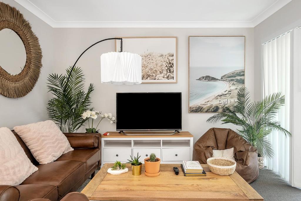 een woonkamer met een bank en een tv bij Stylish 4BR Villa with Office l Modern and Comfy in Marsden Park
