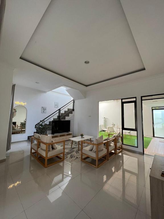ein Wohnzimmer mit einem Tisch, Stühlen und Fenstern in der Unterkunft villa skye in Tarogong