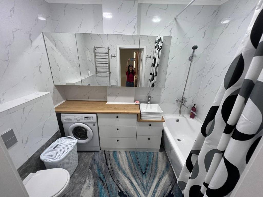 a bathroom with a sink and a washing machine at 3-room elite apartment Alexandria in Bishkek