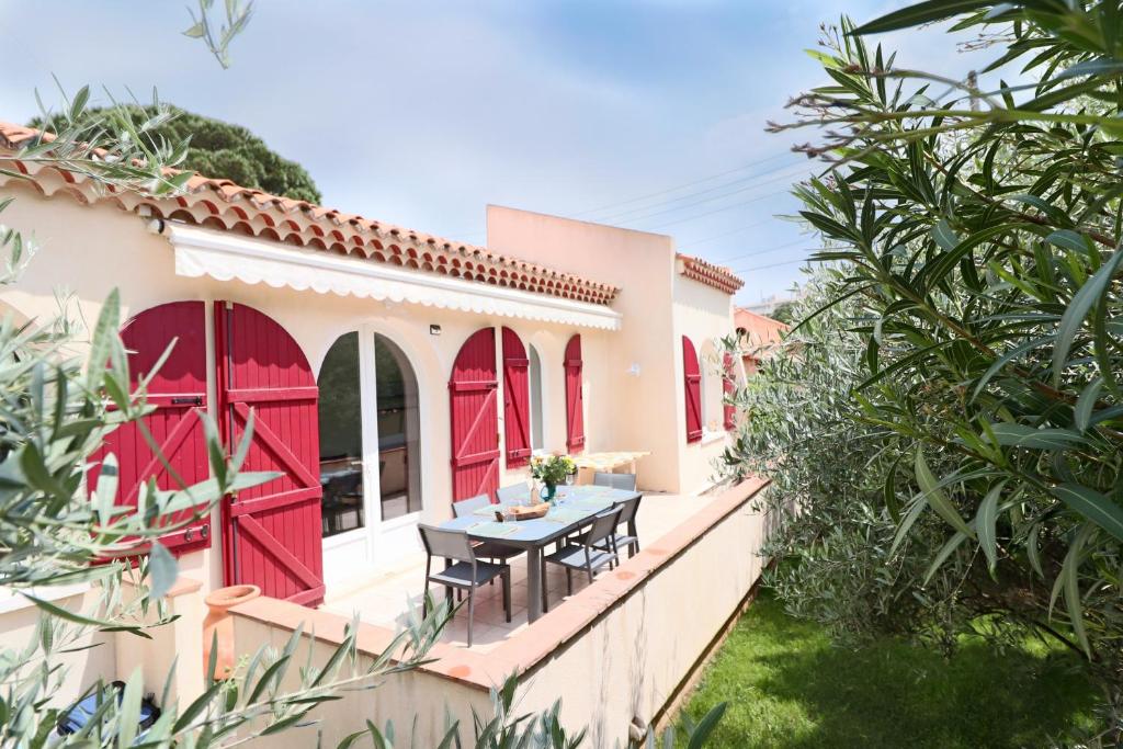 アンティーブにあるLAURIERS Splendide provencale Charming Villa with jacuzzi at 200m from beaches of Juanの赤いドアとバルコニーのテーブル