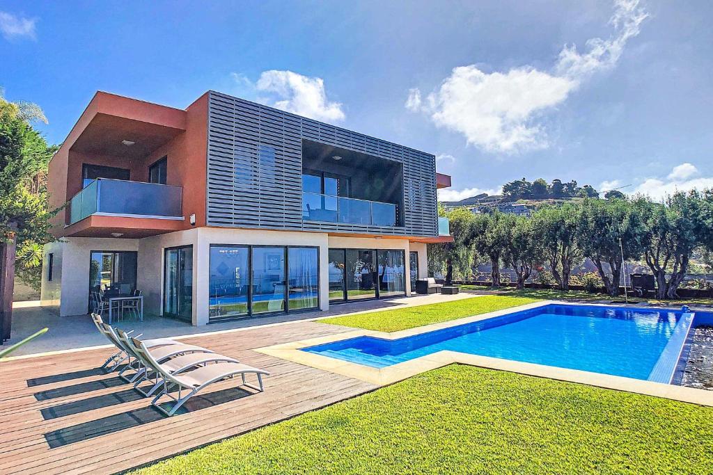 een huis met een zwembad ervoor bij Villa Vitoria Dos in Câmara de Lobos