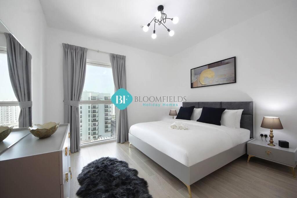 a bedroom with a white bed and a large window at Lavish 1 Bedroom Apartment In Yas Island in Abu Dhabi