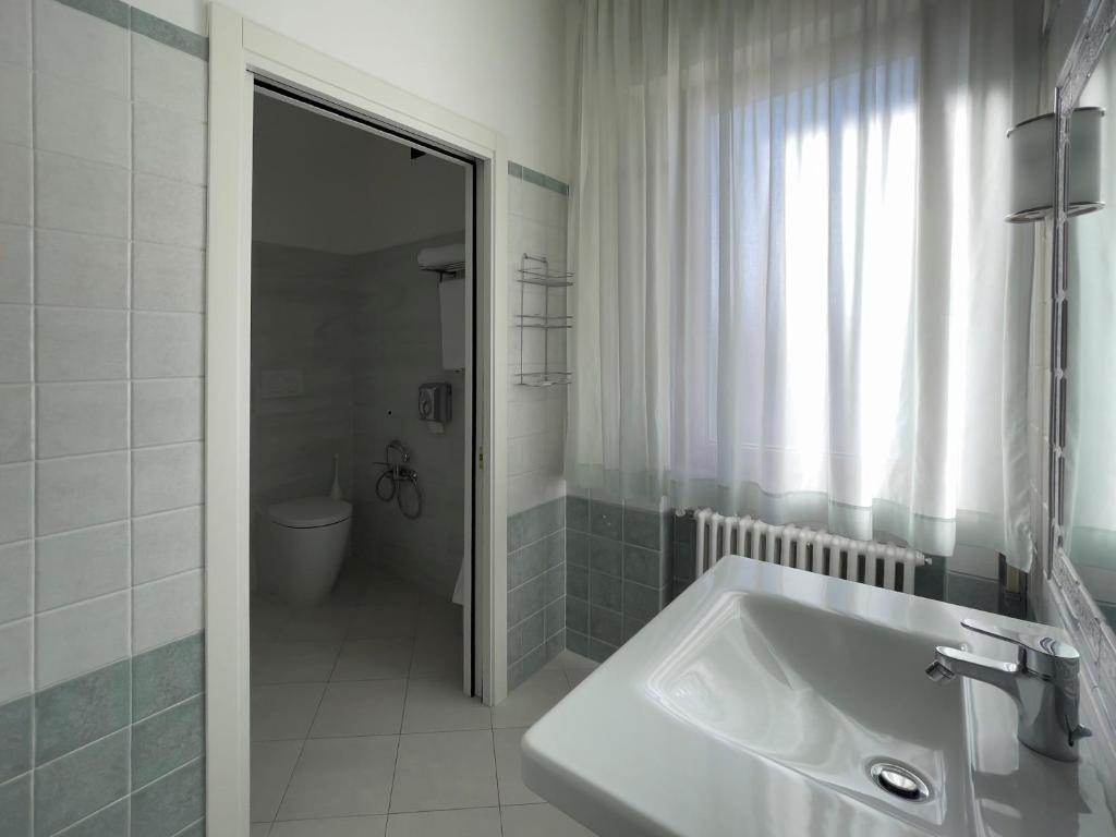 a white bathroom with a sink and a shower at La Lanterna in Silvi Marina