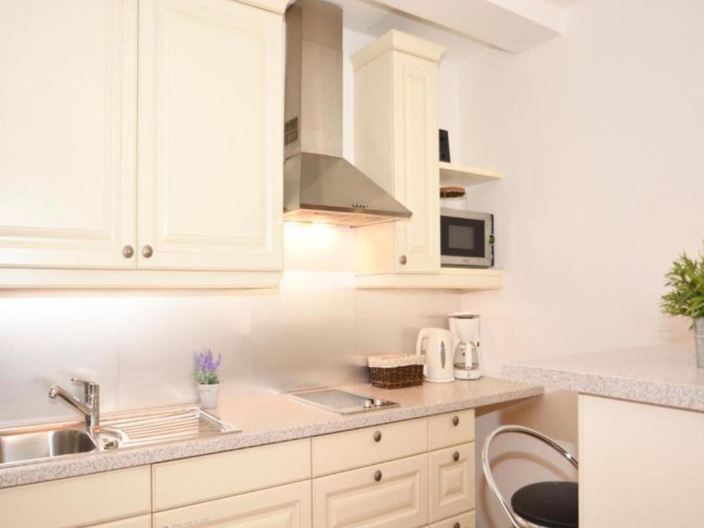a white kitchen with a sink and a microwave at Studio Leif by Interhome in Zell am See